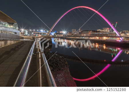 Nightscape view of The Iconic gateshead millennium bridge with Tyne bridge and dark sky in the background. Nightscape view of The Iconic gateshead millennium bridge with Tyne bridge and dark sky in the background. 125152280