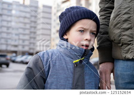 Father and son walking down on sidewalk together. Portrait of a handsome middle-aged man with toddler boy in the urban street. Dad and his child sitting on a bench in city park. City life. Family Father and son walking down on sidewalk together. Portrait of a handsome middle-aged man with toddler boy in the urban street. Dad and his child sitting on a bench in city park. City life. Family 125152634