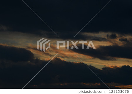 Black sky. Bad weather. Fluffy clouds. Light breaks through the clouds. Universal horizontal photo. The background picture.  125153076