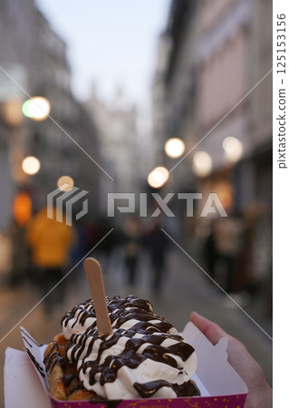 Belgian Waffle with Chocolate and Cream Held on Busy Brussels Street 125153156
