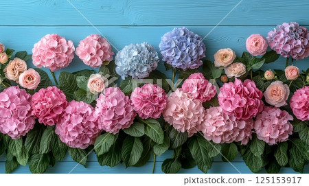 Soft Pastel Floral Design Featuring Hydrangeas and Roses on Blue Wooden Background Soft Pastel Floral Design Featuring Hydrangeas and Roses on Blue Wooden Background 125153917