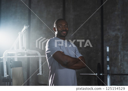 Fitness workout in gym. Portrait of African American man standing in gym with motivation health energy ready for training. Athletic coach personal trainer fitness club owner. Healthy lifestyle Fitness workout in gym. Portrait of African American man standing in gym with motivation health energy ready for training. Athletic coach personal trainer fitness club owner. Healthy lifestyle 125154529