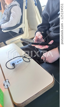 A person using a smartphone while charging A person using a smartphone while charging 125154551