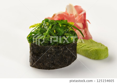 Gunkan maki sushi with chukka seaweed, pickled ginger and wasabi on white background Gunkan maki sushi with chukka seaweed, pickled ginger and wasabi on white background 125154605