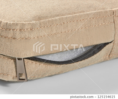 Open zipper showing foam filling of beige fabric cushion Open zipper showing foam filling of beige fabric cushion 125154615