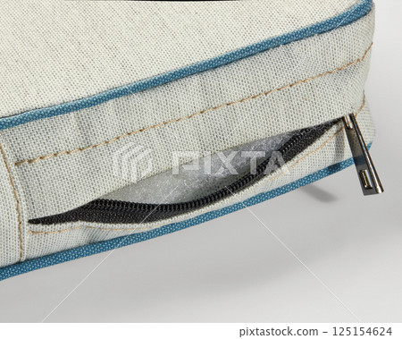 Close-up of zipper on outdoor cushion revealing foam filling Close-up of zipper on outdoor cushion revealing foam filling 125154624