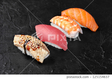 Delicious nigiri sushi with eel, tuna, shrimp and salmon on black background 125154637