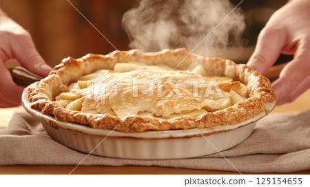 Freshly baked apple tart with cinnamon, walnuts, and golden crust. Styled in soft natural light on a rustic wooden table. Ideal for seasonal baking and holiday visuals. 125154655