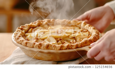 Rustic apple pie with flaky lattice crust and golden caramel filling. A cozy homemade dessert styled with powdered sugar on ceramic plate. Perfect for winter comfort food scenes. 125154656