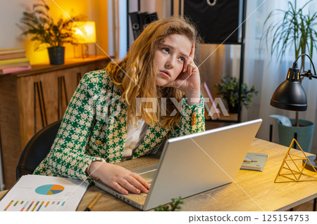 Bored sleepy businesswoman worker working on laptop computer yawns leaning on hand at office desk Bored sleepy businesswoman worker working on laptop computer yawns leaning on hand at office desk 125154753