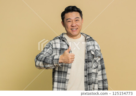 Asian man raises thumbs up agrees give positive reply recommends advertisement likes good idea Asian man raises thumbs up agrees give positive reply recommends advertisement likes good idea 125154773