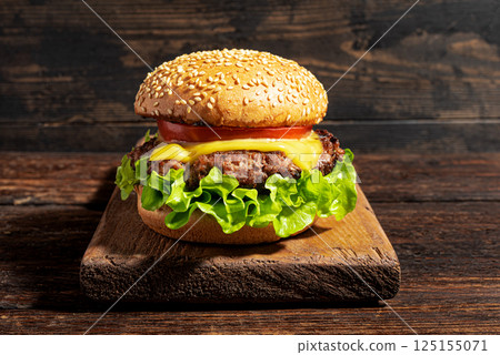 Homemade burger, cheeseburger on dark wooden background Homemade burger, cheeseburger on dark wooden background 125155071
