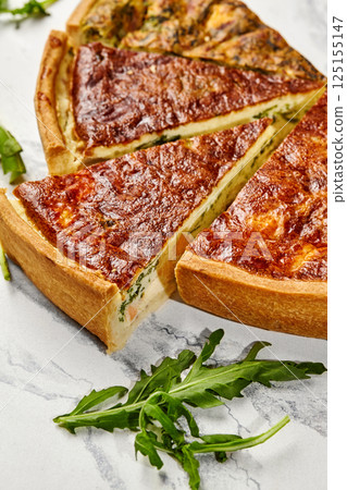 Delicious homemade quiche with salmon and spinach filling sliced and ready to serve 125155147
