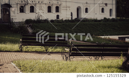 The park benches in this serene setting await visitors who seek a moment of peace. The park benches in this serene setting await visitors who seek a moment of peace. 125155329