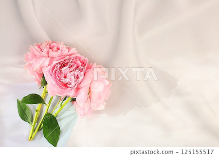 Bouquet of delicate flowers peonies, roses on a sunny table for a gift to loved ones. Spring still life and banner for the screen, elegant beauty concept, template for design. 125155517