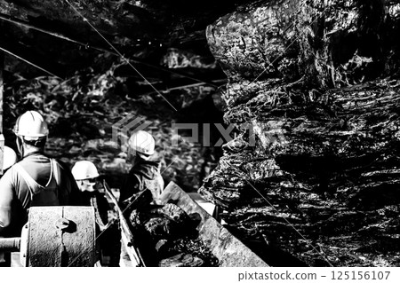 Selective focus on anthracite coal on a conveyer belt with defocused group in the Lackawanna Coal Mine Tour at McDade Park. Selective focus on anthracite coal on a conveyer belt with defocused group in the Lackawanna Coal Mine Tour at McDade Park. 125156107