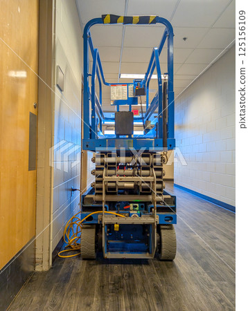 open gate to a scissor lift lowered inside a building construction project. open gate to a scissor lift lowered inside a building construction project. 125156109