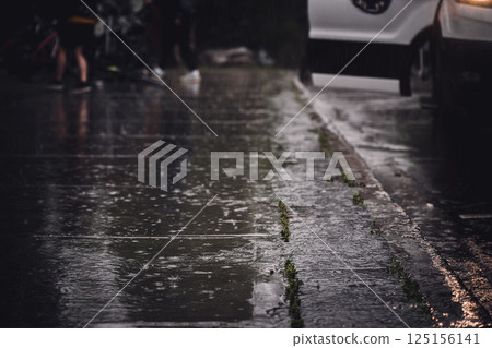 Sidewalk during a rain downpour with standing water Sidewalk during a rain downpour with standing water 125156141