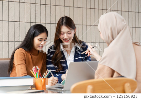 Group Learning and Friendship. Joyful students celebrating their teamwork while studying in a cafe. Group Learning and Friendship. Joyful students celebrating their teamwork while studying in a cafe. 125156925