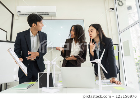 Sustainability and Team Collaboration. A group discussing sustainable practices in a modern office. 125156976