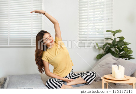 Stretching and Wellness. A woman engages in gentle stretching exercises for a healthy start. Stretching and Wellness. A woman engages in gentle stretching exercises for a healthy start. 125157115