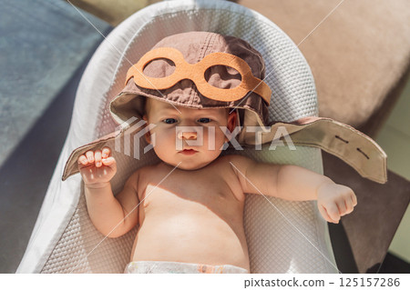 Baby wearing a pilot hat, symbolizing early dreams of aviation. Concept of learning to fly, future pilot, and childhood aspirations. Aviation, imagination, and career inspiration concept Baby wearing a pilot hat, symbolizing early dreams of aviation. Concept of learning to fly, future pilot, and childhood aspirations. Aviation, imagination, and career inspiration concept 125157286
