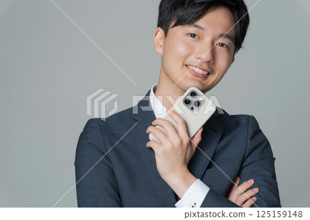 身穿西裝、手持智慧型手機的男子的肖像 125159148