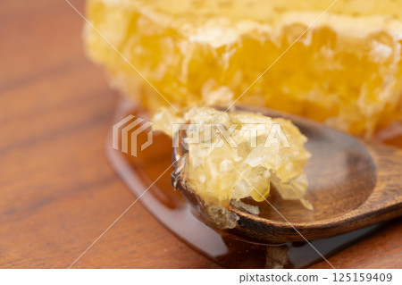 Close-up of comb honey crumbled with a spoon 125159409