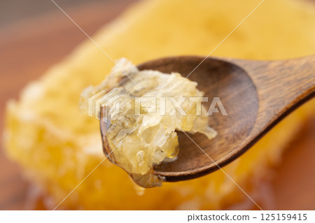 Close-up of comb honey crumbled with a spoon 125159415
