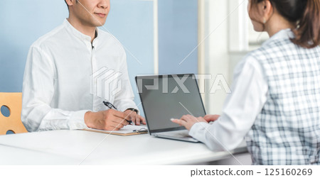 A male customer at the reception desk and a female office staff member handling the customer service A male customer at the reception desk and a female office staff member handling the customer service 125160269