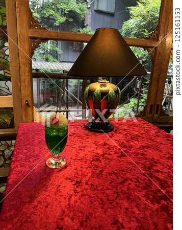 A window table with a retro-modern lamp and cream soda A window table with a retro-modern lamp and cream soda 125161153
