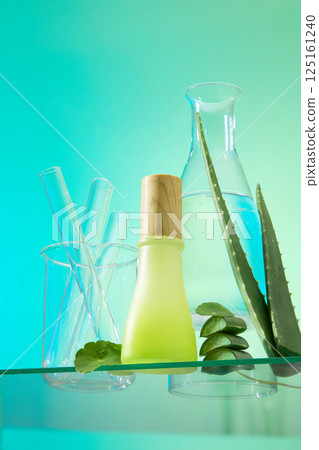 Fresh aloe vera with sharp thorns and cut aloe vera placed next to the glass bottle containing the essence. Graduated cylinder placed in the laboratory beaker, next to a tall water bottle. Fresh aloe vera with sharp thorns and cut aloe vera placed next to the glass bottle containing the essence. Graduated cylinder placed in the laboratory beaker, next to a tall water bottle. 125161240