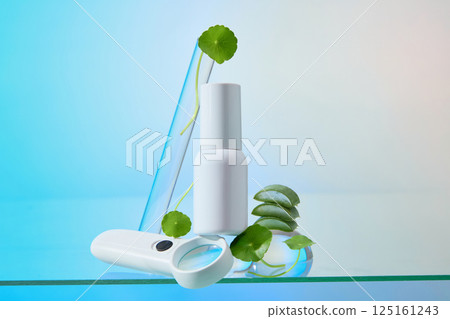 Cylindrical plastic bottles placed on top of magnifying glasses and glass sphere, surrounded by cut aloe vera placed on top of each other. Gotu kola with soft stems placed scattered for decoration. Cylindrical plastic bottles placed on top of magnifying glasses and glass sphere, surrounded by cut aloe vera placed on top of each other. Gotu kola with soft stems placed scattered for decoration. 125161243