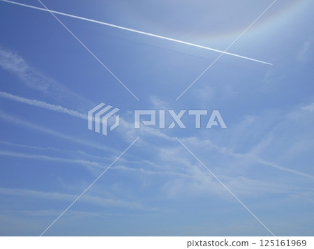 A contrail stretches out under the blue sky A contrail stretches out under the blue sky 125161969
