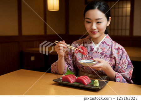 Woman eating tuna sashimi Woman eating tuna sashimi 125163025
