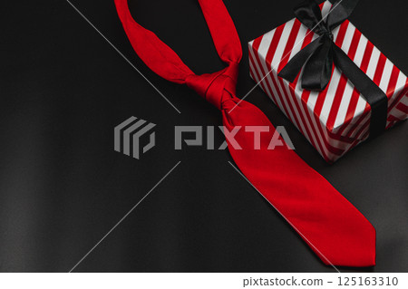 Celebrating Father's Day with a stylish red tie and a festive gift Celebrating Father's Day with a stylish red tie and a festive gift 125163310