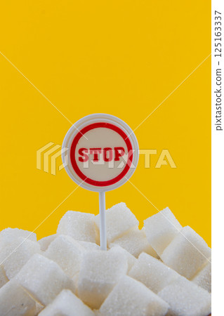 Bright yellow background highlights sugar cubes with a stop sign 125163337