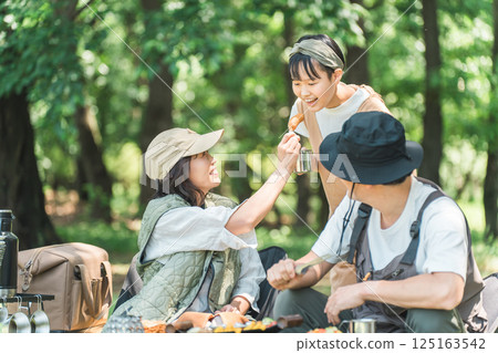 A friendly family enjoying day camping, camping and barbecues at a park or campsite 125163542