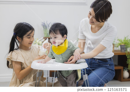 Family giving baby food and milk to a baby 125163571
