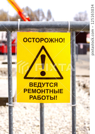 Signboard. Text in russian: Caution, renovation work in progress Signboard. Text in russian: Caution, renovation work in progress 125163834