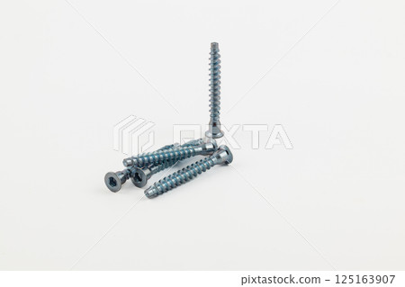 Metallic screws arranged on a neutral background Metallic screws arranged on a neutral background 125163907