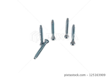 Various metal screws arranged on a light background 125163909