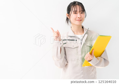 Young female engineer pointing at something on white background 125164010