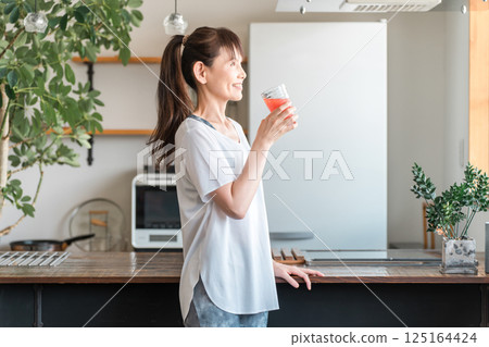 Middle-aged Asian woman in sportswear drinking vegetable juice (beauty, nutrition, diet, beautiful skin) Middle-aged Asian woman in sportswear drinking vegetable juice (beauty, nutrition, diet, beautiful skin) 125164424