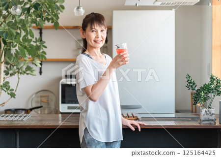 身穿運動服的中年亞洲女性喝蔬菜汁（美容、營養、飲食、美麗肌膚） 125164425