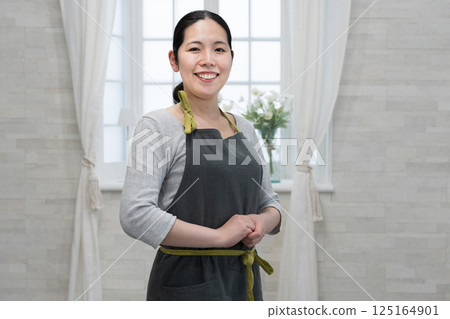有圍裙的微笑的一名婦女 125164901