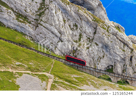 Cogwheel train climbing to the top of Mount Pilatus in Canton Lucerne, Switzerland. World's steepest cogwheel railway Cogwheel train climbing to the top of Mount Pilatus in Canton Lucerne, Switzerland. World's steepest cogwheel railway 125165244