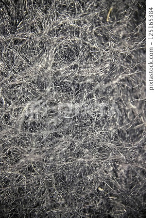 Detailed Microscopic View of Fabric Under a Microscope.Close-up view of fabric fibers under a microscope, revealing intricate texture and structural complexity. 125165384