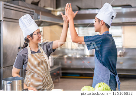 Happy Young Chefs High-Fiving in Kitchen After Preparing Sandwiches 125166832