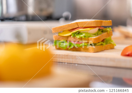 Fresh Homemade Sandwich with Vegetables on Wooden Cutting Board Fresh Homemade Sandwich with Vegetables on Wooden Cutting Board 125166845